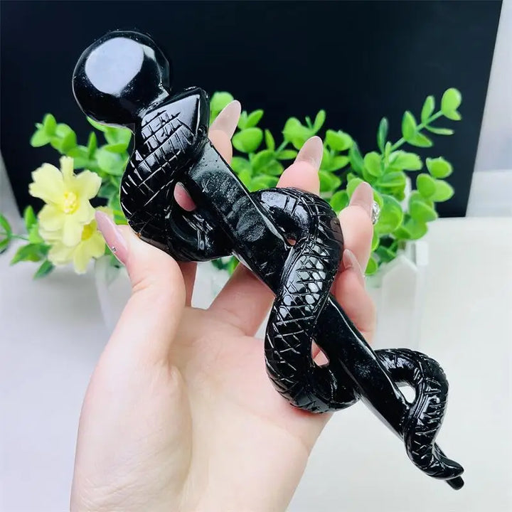 Hand-carved black obsidian snake staff, a polished crystal symbol of healing, transformation, and protective energy.