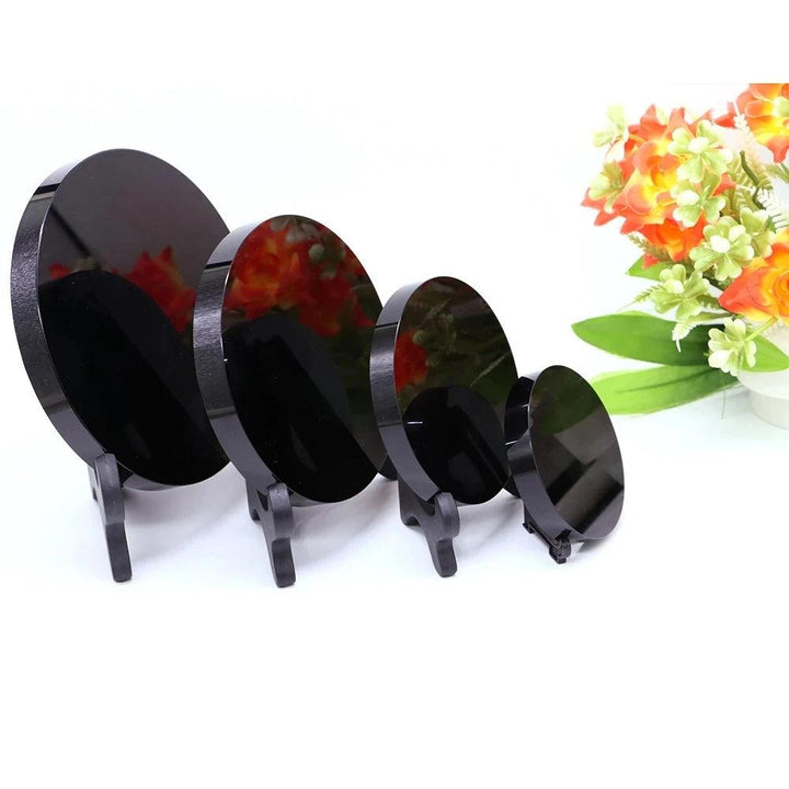 Polished black obsidian scrying mirrors with stands, showcasing various sizes for divination and self-reflection.