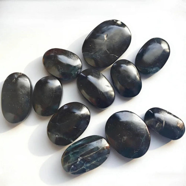 Polished black rose fluorite crystal palm stones for healing and meditation.
