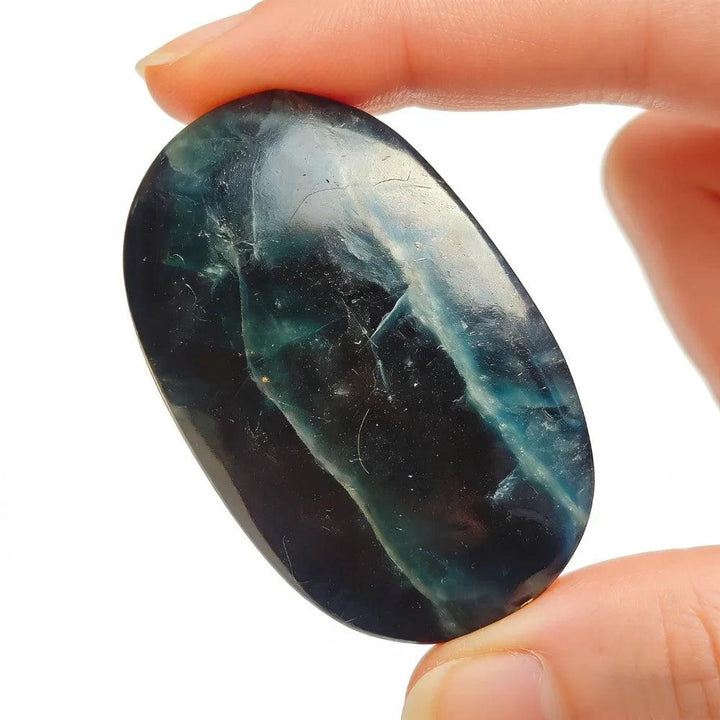 Polished black rose fluorite crystal palm stone with deep blue-green veins for healing.