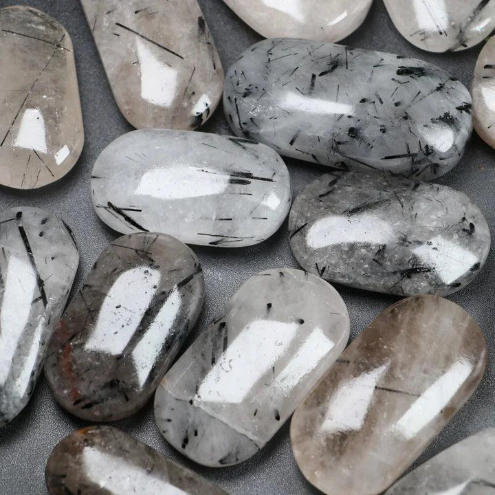 Polished natural Black Rutilated Quartz palm stones with unique black needle inclusions for healing and home decor.