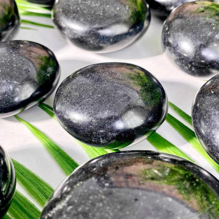 Polished black tourmaline palmstones with natural striations, perfect for grounding and root chakra meditation.