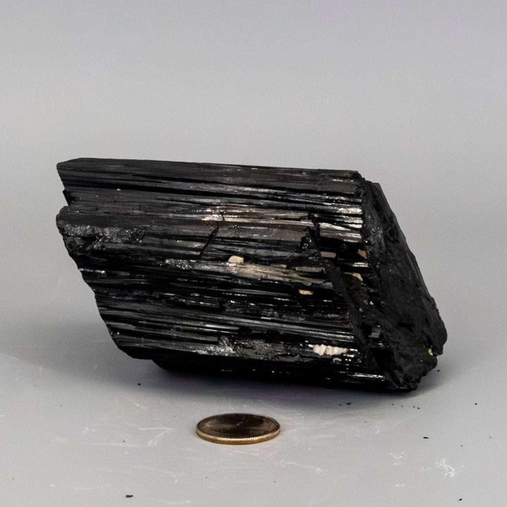 Large, raw black tourmaline crystal hunk with natural striated texture, perfect for grounding and protection.