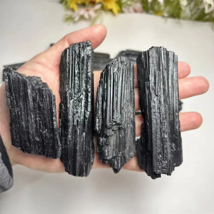 Large raw black tourmaline stones with natural vertical striations, perfect for healing, grounding, and home decor.