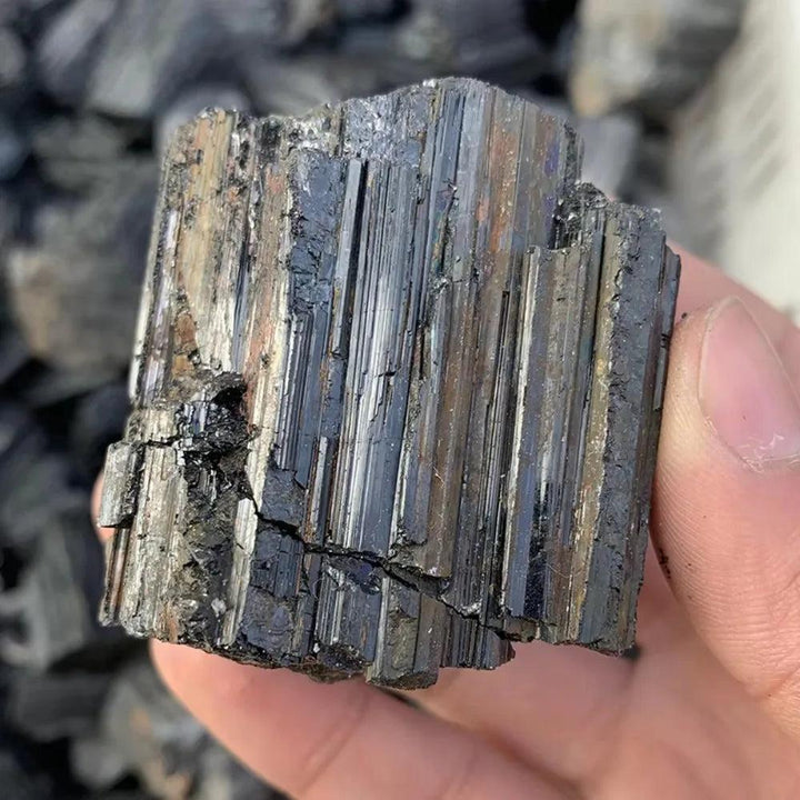 Raw Black Tourmaline specimen featuring deep black, striated crystal structures for powerful grounding and protection.