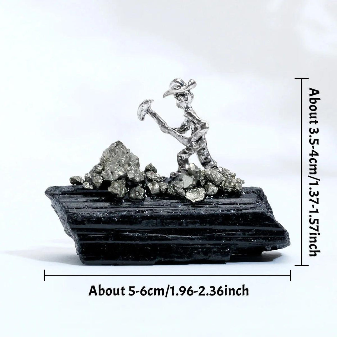 Raw black tourmaline crystal with a metal miner figurine for grounding, protection, and root chakra healing.
