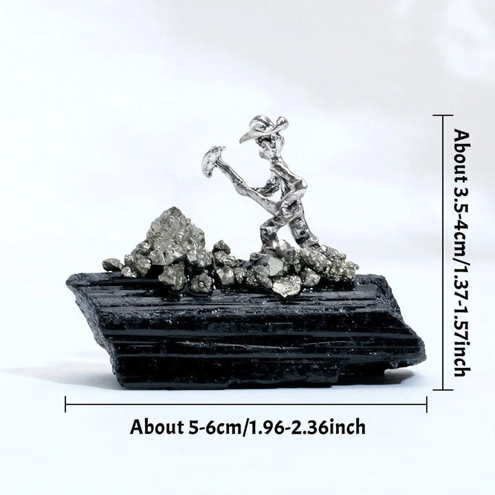 Raw black tourmaline crystal with a metal miner figurine for grounding, protection, and root chakra healing.