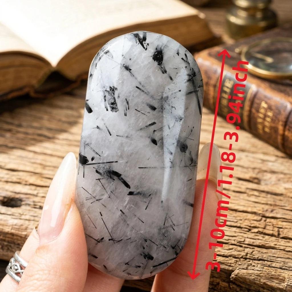 Polished black tourmaline in quartz palm stone with protective, grounding energy.