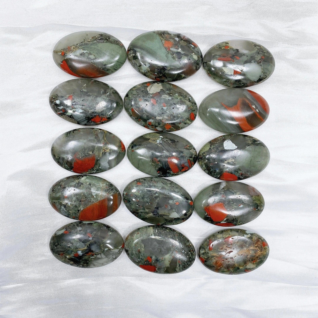 Polished bloodstone palm stones, dark green with vivid red spots, for healing and protection.