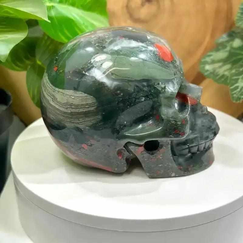 Hand-polished Bloodstone skull carving, 40-50mm deep green stone with red flecks for courage and root chakra healing.