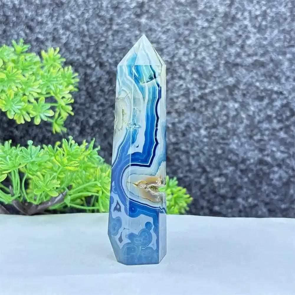 Polished blue agate hexagonal tower with soothing blue banding, perfect for Throat Chakra healing and desk decor.