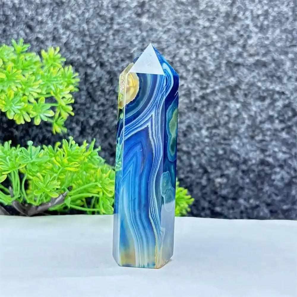 Polished blue agate hexagonal tower with soothing blue banding, perfect for Throat Chakra healing and calm desk decor.