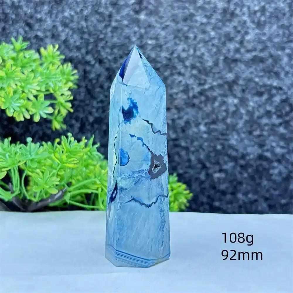 Polished blue agate hexagonal tower with soft blue banding, perfect for Throat Chakra healing and calming desk decor.