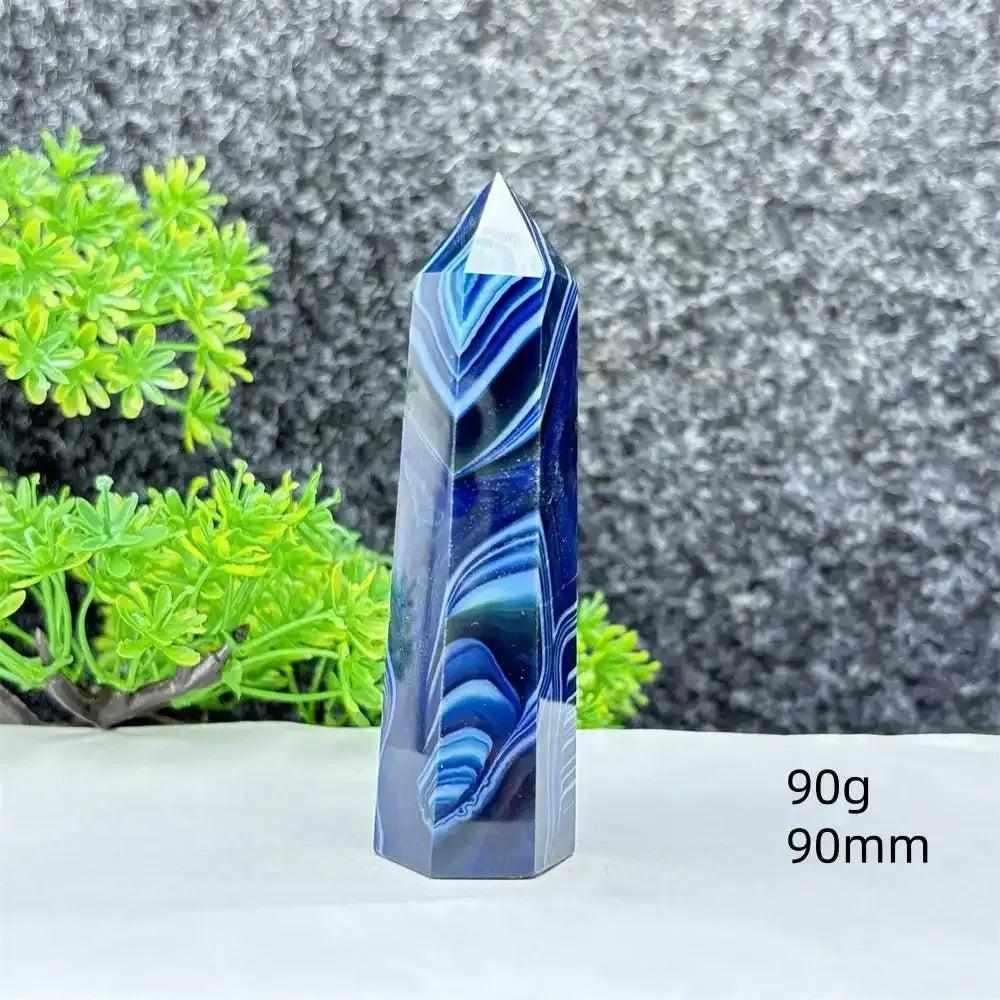 Polished blue agate hexagonal tower with striking deep blue banding, perfect for throat chakra healing and desk decor.