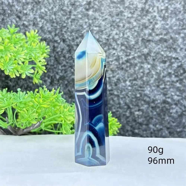 Polished blue agate hexagonal tower with soft blue banding, perfect for Throat Chakra healing and calming desk decor.