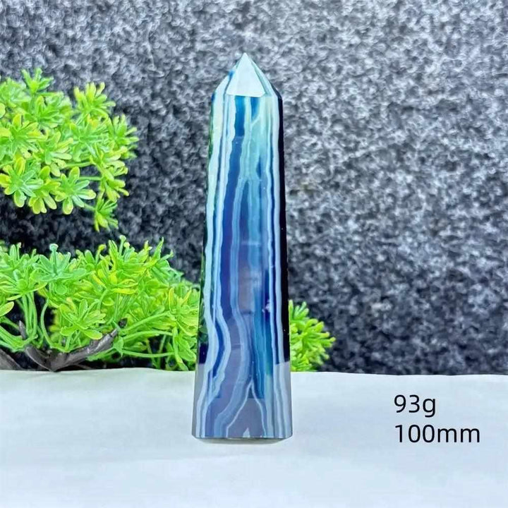 Polished blue agate hexagonal tower with soothing blue banding, perfect for Throat Chakra healing and desk decor.