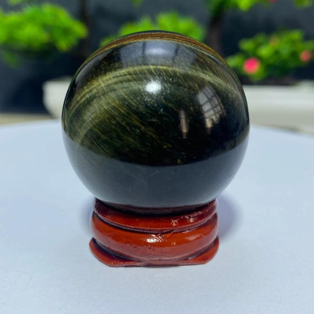 Polished Blue Yellow Tiger Eye crystal ball on a wooden stand, perfect for Reiki healing, meditation, and home decor.