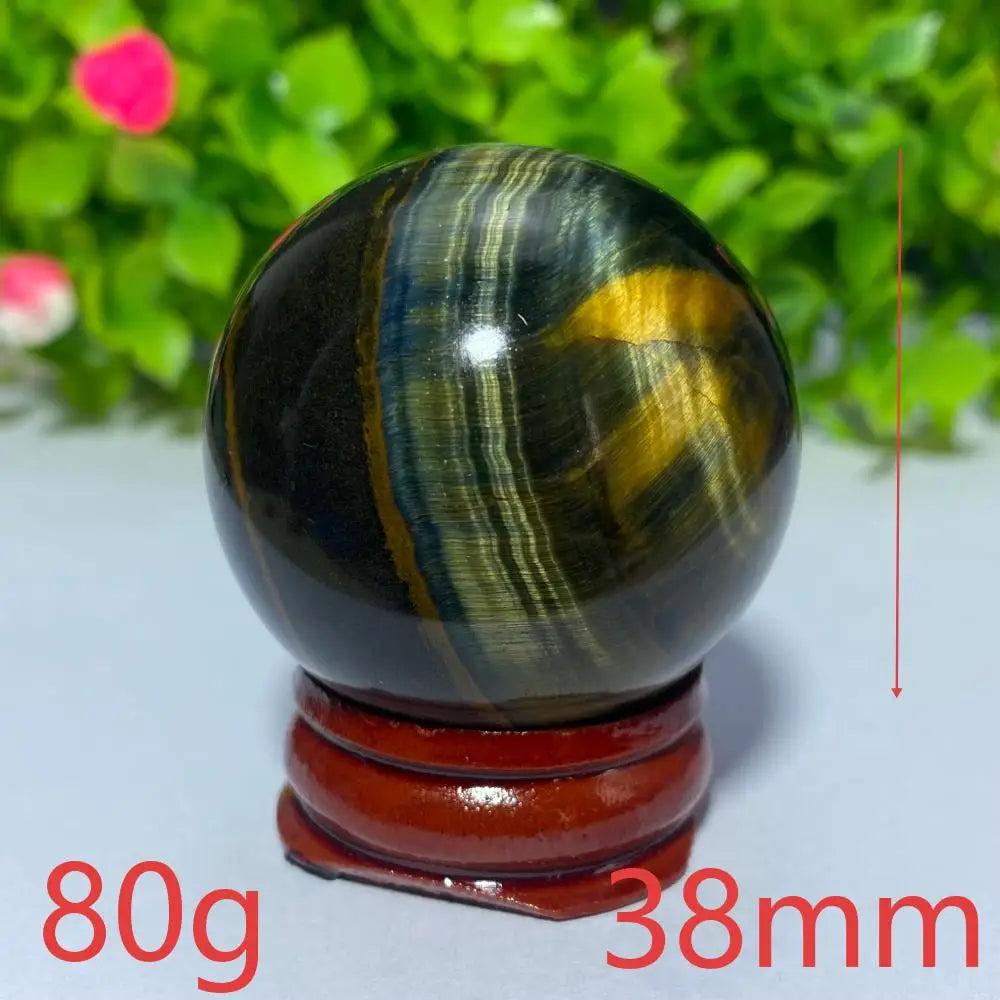 38mm Blue and Yellow Tiger Eye crystal ball for Reiki healing, meditation, and spiritual home decor on a wooden stand.