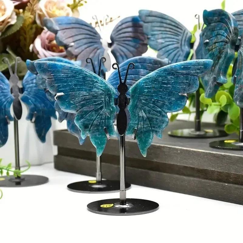Vivid electric teal-blue Apatite butterfly wings crystal carving on a stand, symbolizing transformation and clarity.