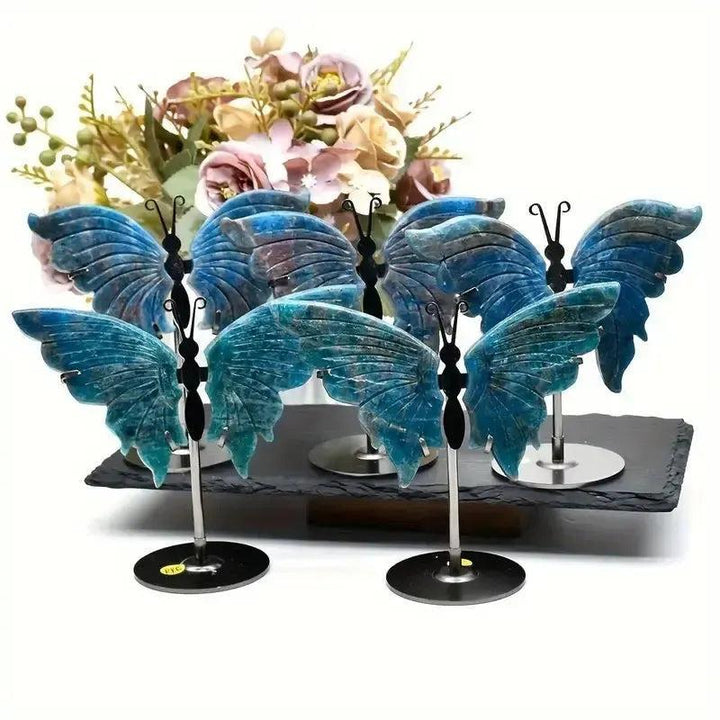 Vivid electric teal-blue Apatite butterfly wings crystal carvings on stands, symbolizing transformation and clarity.