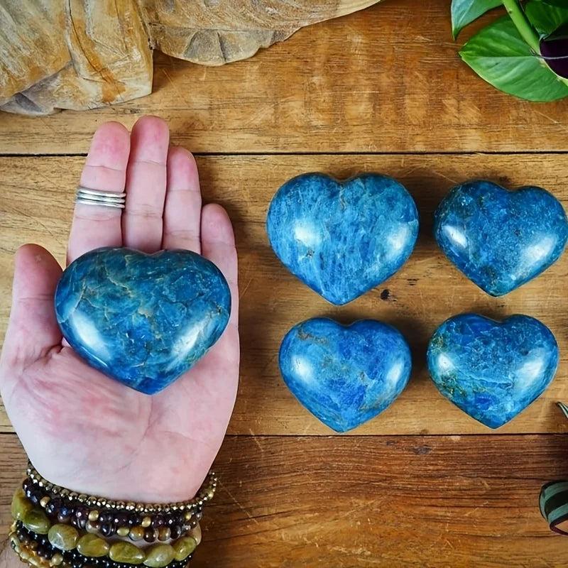 Polished Blue Apatite crystal heart palm stones in a vivid blue-green, perfect for meditation and manifestation.