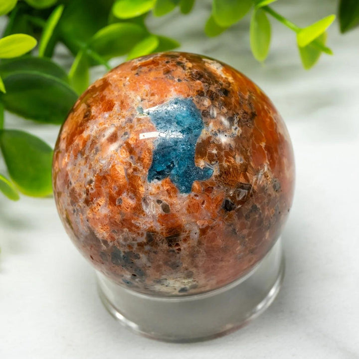 Polished Blue Apatite Sunstone Crystal Sphere with vibrant orange and blue tones for energy and manifestation.