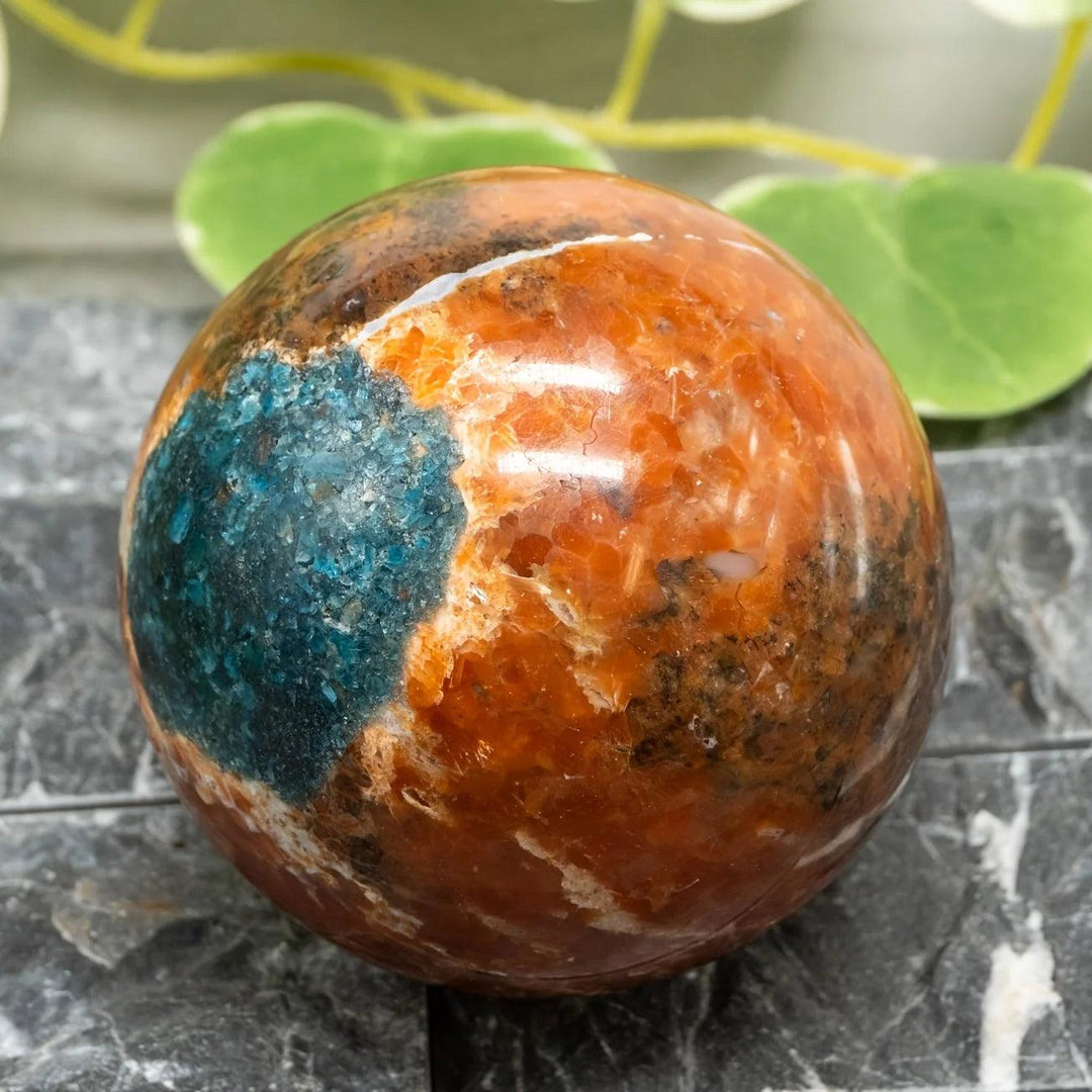 Blue Apatite Sunstone Crystal Sphere with vibrant orange and blue tones for energy and manifestation.