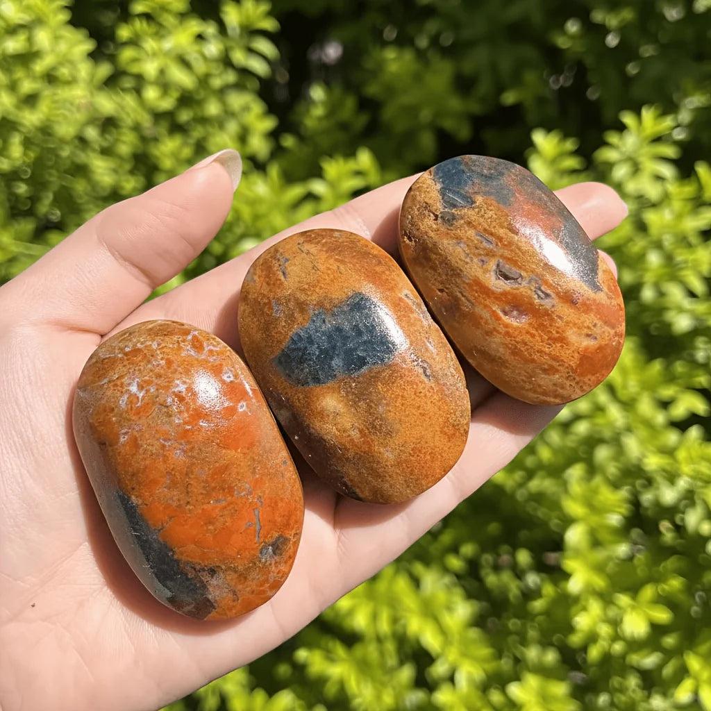 Polished Blue Apatite with Sunstone palm stones showing vibrant orange and blue healing crystals.
