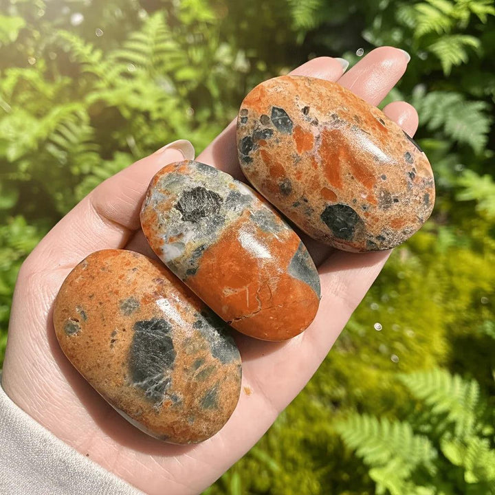 Polished blue apatite with sunstone palm stones showing natural orange and blue-grey gradients.