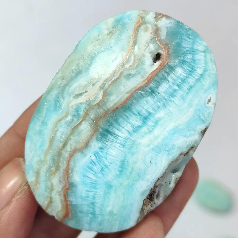 Polished Blue Aragonite palm stone with calming sky-blue hues and natural banding for emotional healing and tranquility.