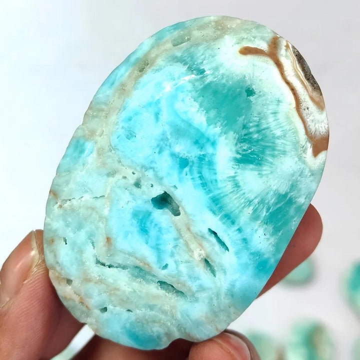 Polished Blue Aragonite palm stone with calming sky-blue hues and natural banding for emotional healing and tranquility.