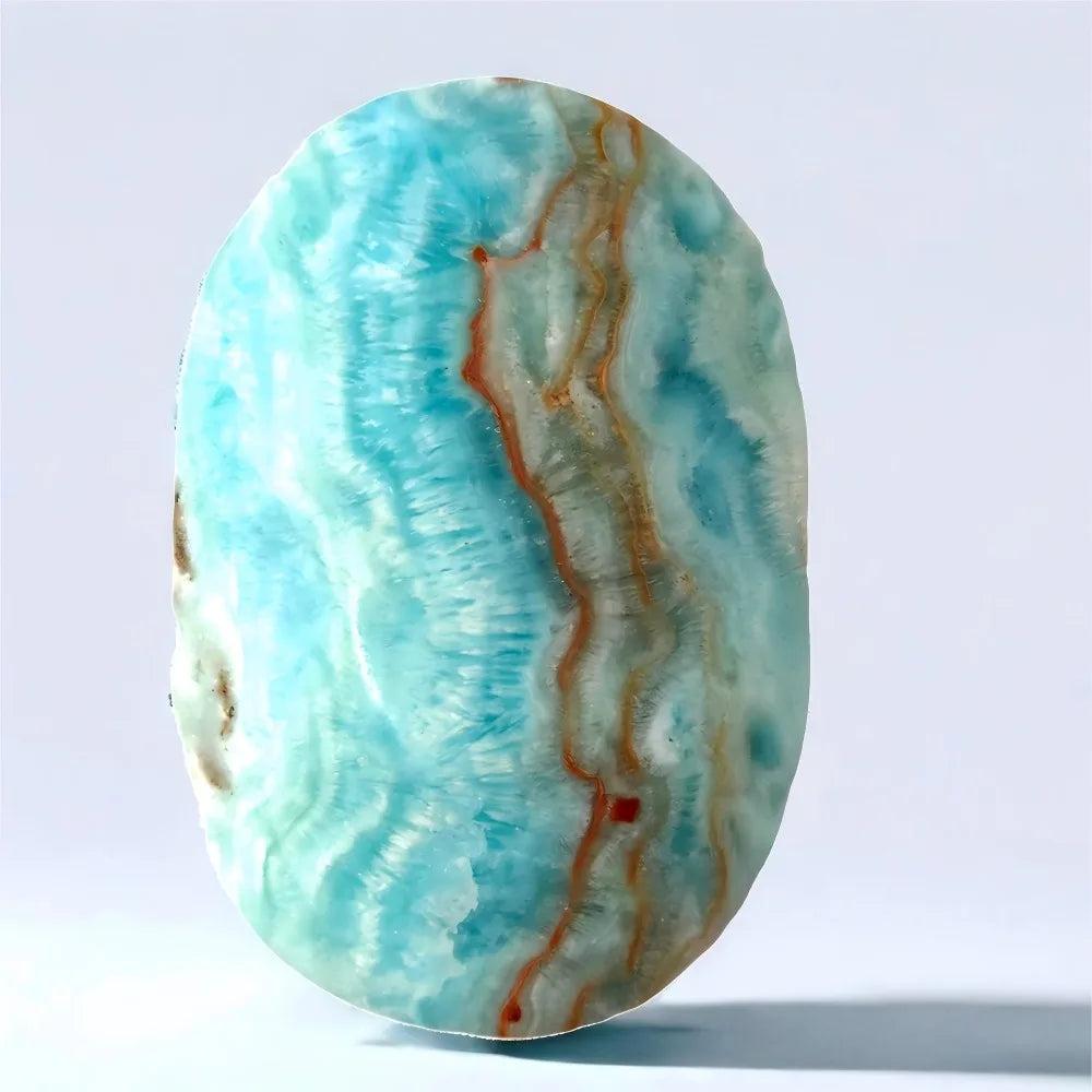 Polished blue aragonite palm stone with calming sky-blue hues and natural banding for peaceful emotional healing.