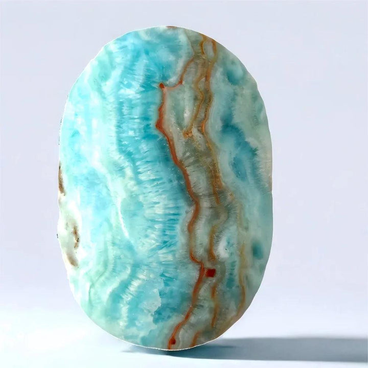Polished blue aragonite palm stone with calming sky-blue hues and natural banding for peaceful emotional healing.