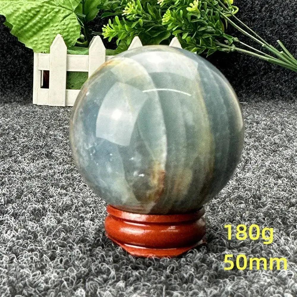 Stunning Blue Calcite Crystal Sphere, 50mm, 180g, on a wooden stand, radiating serene beauty and soothing energy.