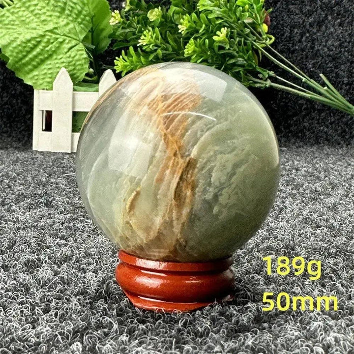 Stunning Blue Calcite Crystal Sphere, 50mm, 189g, with serene blue and brown tones on a wooden stand.