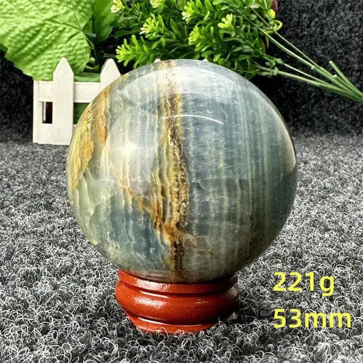 Stunning Blue Calcite Crystal Sphere, hand-polished with serene blue and golden tones, promoting peace and emotional healing.