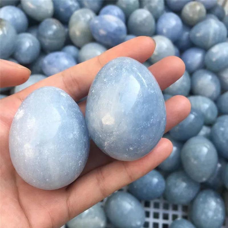 Hand holding two polished Blue Celestite Crystal Eggs, radiating peace and calm.