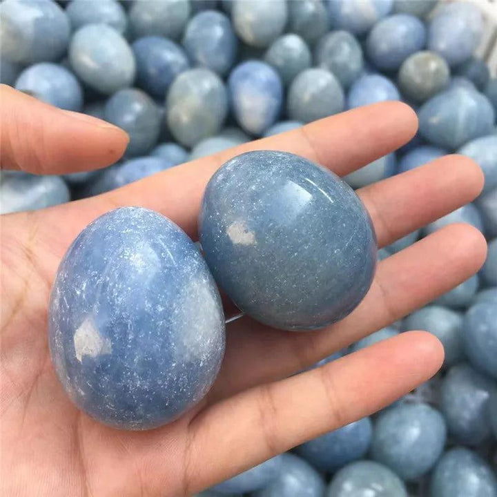 Two polished Blue Celestite crystal eggs, 40-50mm, held in a hand, radiating peace and calm.