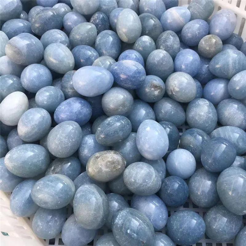 Pile of smooth, polished Blue Celestite crystal eggs, radiating peace and calm with their soft, hazy blue hues.