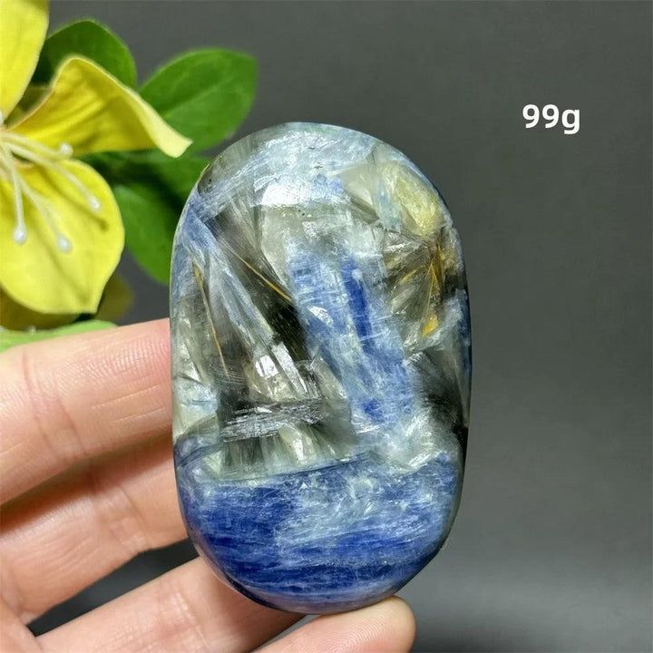 Polished 99g blue kyanite palm stone with deep striated blue ribbons for grounding, peace, and throat chakra healing.