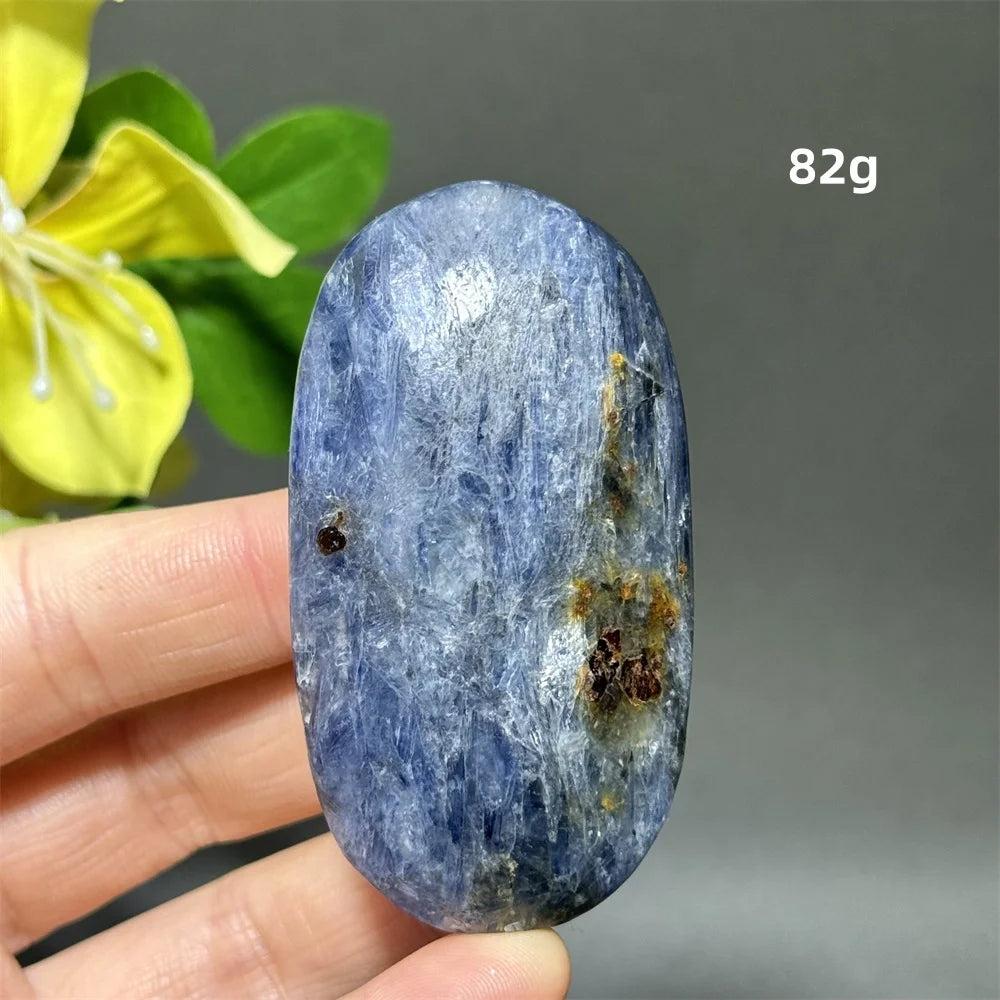 Polished 82g blue kyanite palm stone with deep striated blue ribbons for throat chakra healing and peaceful grounding.