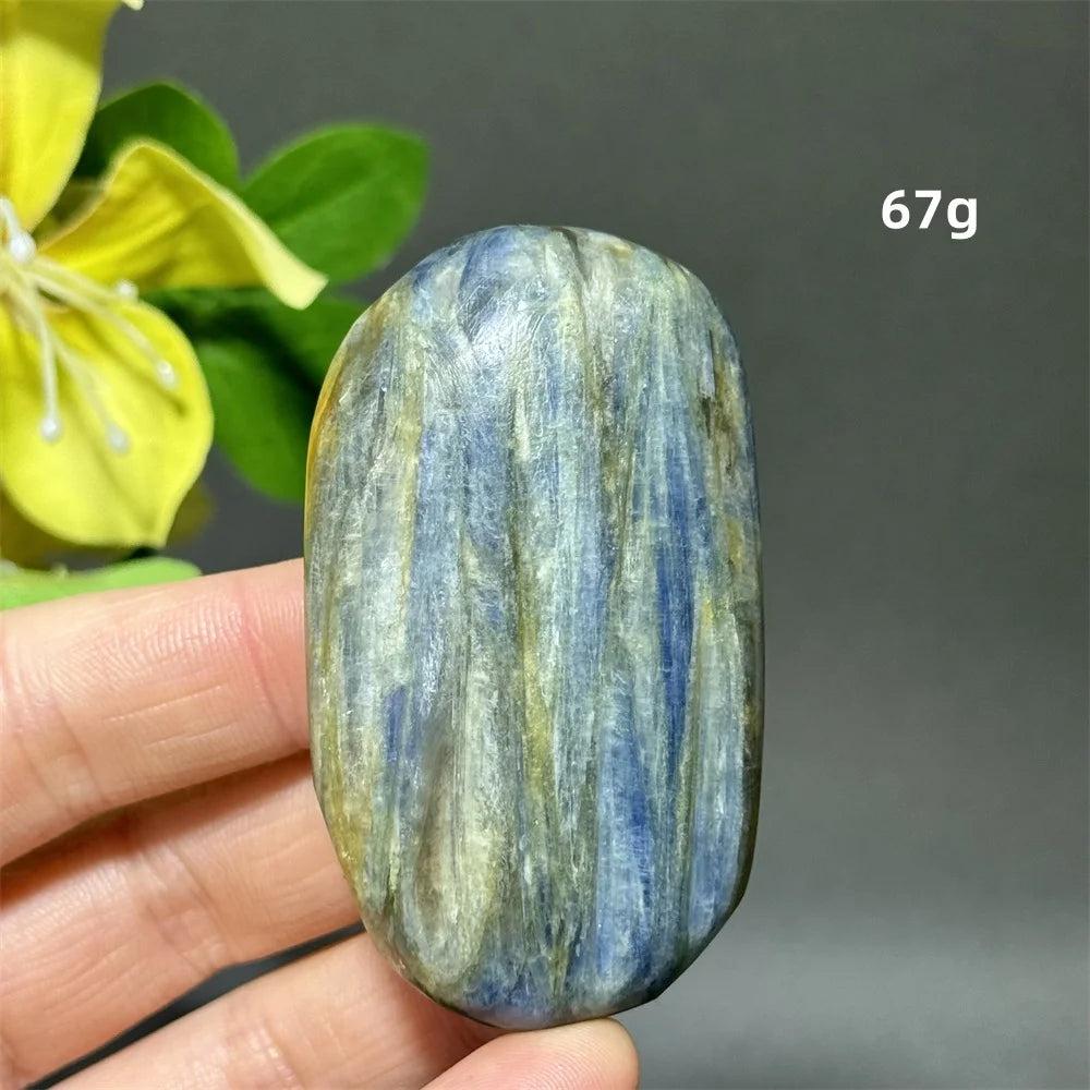 Polished 67g blue kyanite palm stone with silky, striated blue ribbons for grounding, peace, and chakra healing.