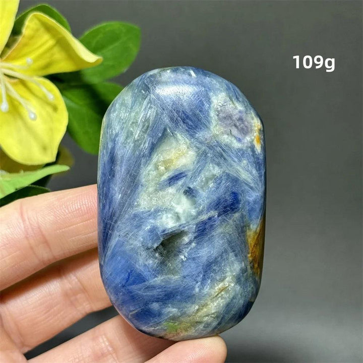 Polished 109g blue kyanite palm stone with deep striated blue ribbons for grounding, peace, and throat chakra healing.