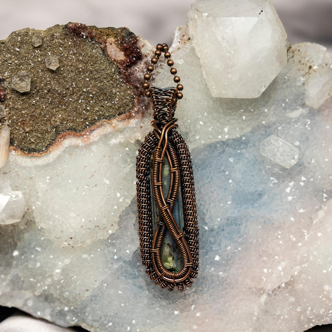 Elegant Kyanite Wire Wrap Pendant with a blue blade, wrapped in healing copper, showcasing natural striations.