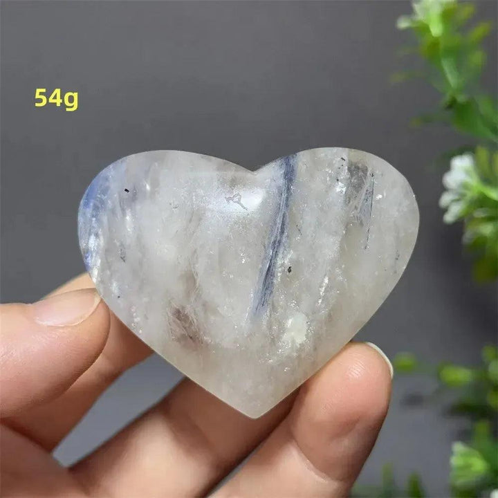 Blue Apatite Crystal Heart: Polished, translucent heart-shaped crystal with subtle blue veins, held in a hand.