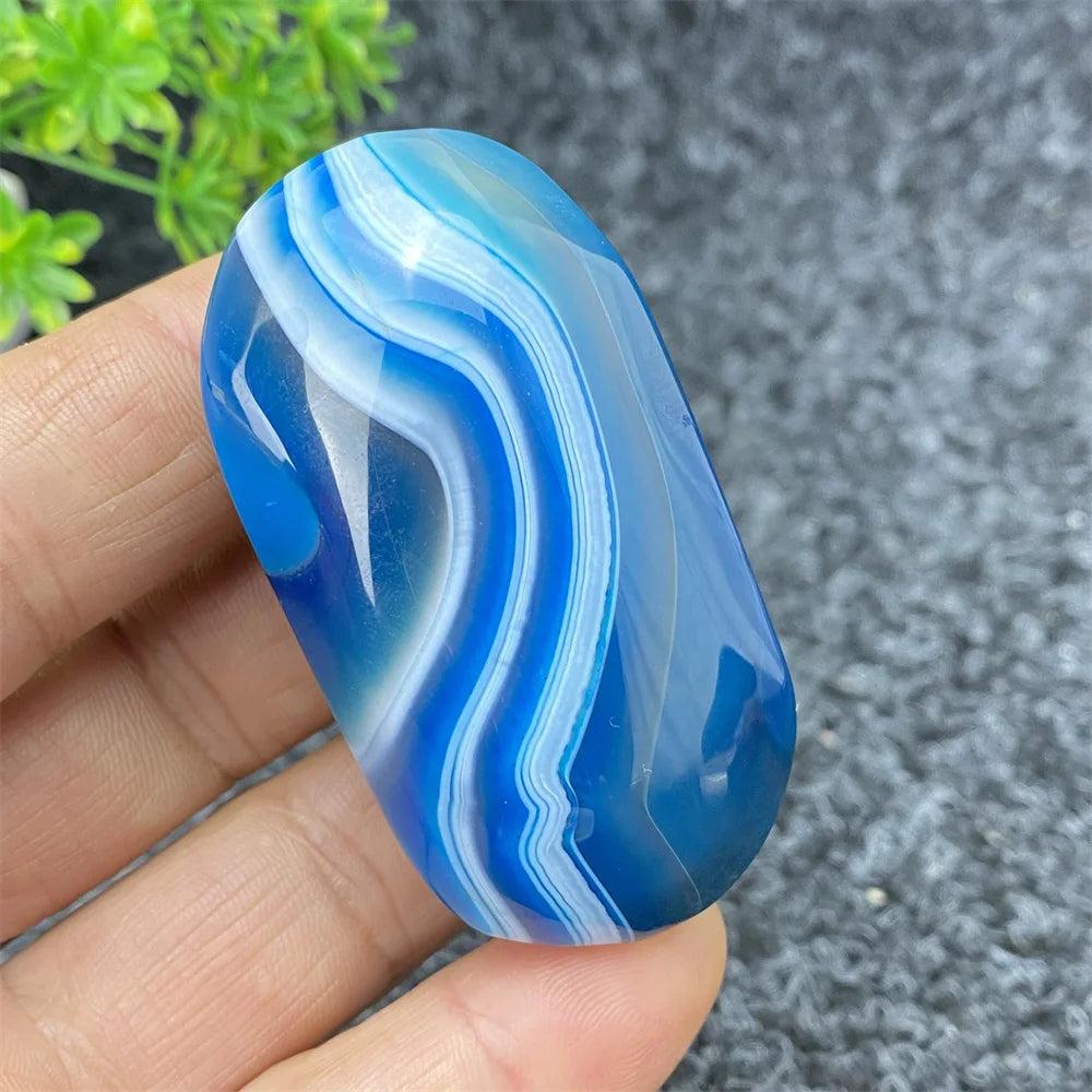 Hand-polished Blue Lace Agate palm stone featuring calming blue swirls and soothing energy for home decor or meditation.