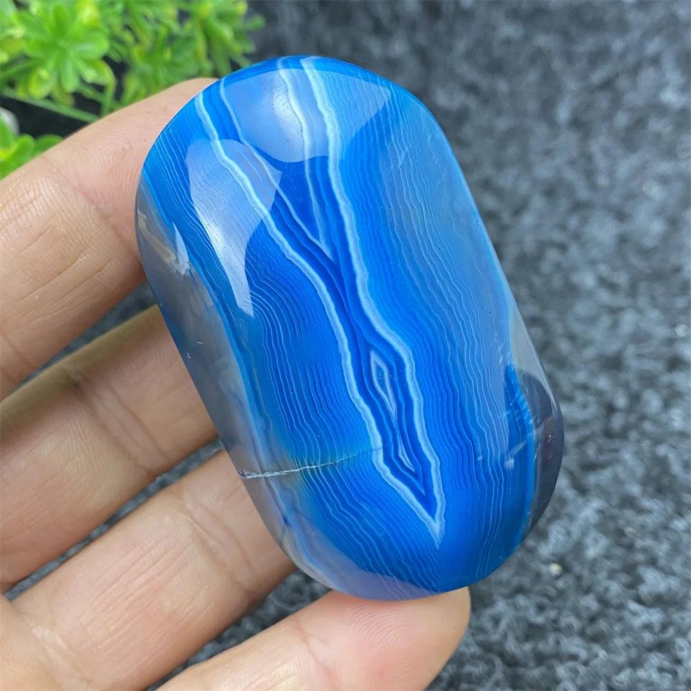 Polished Blue Lace Agate palm stone featuring calming blue banded patterns, perfect for healing, meditation, and decor.