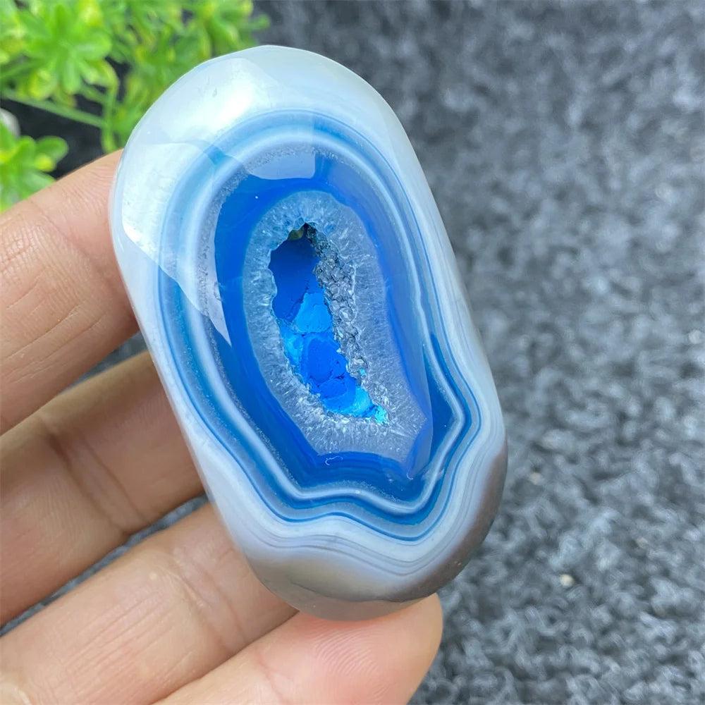 Polished Blue Lace Agate palm stone with a vibrant, sparkling crystal geode center for calming home decor and healing.