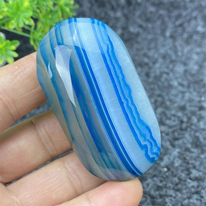 Polished Blue Lace Agate palm stone with calming blue banded patterns, perfect for healing, meditation, and home decor.