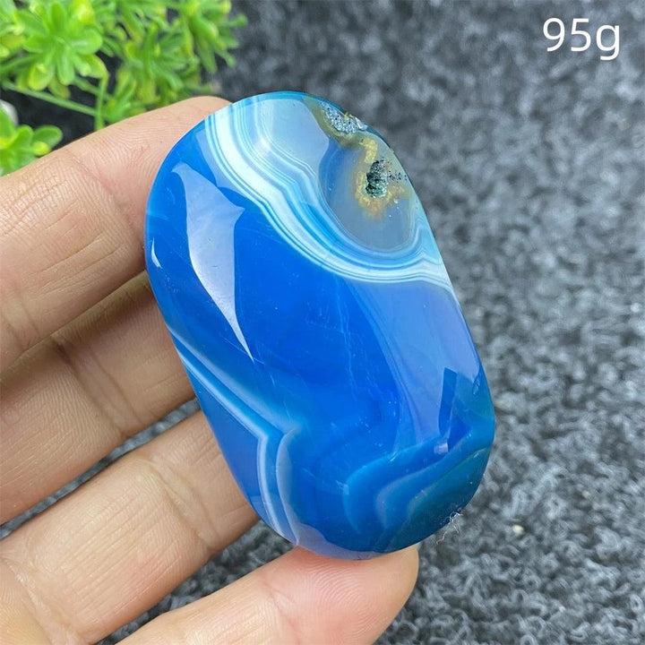 Polished 95g Blue Lace Agate palm stone with calming blue banded patterns, perfect for healing and home decor.